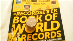 Tallest Tower Of West Virginia State Quarters Balanced On A "RecordSetter Book Of World Records"