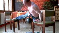 Most Consecutive One-Armed Back-Of-Hand Push-Ups On Three Chairs While Carrying A 20-Kilogram Kettlebell