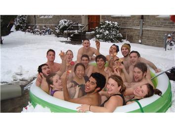 Most College Students In An Inflatable Pool Eating Pizza With Snow On The Ground