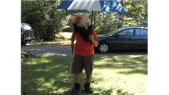 Most Golf Ball Bounces On A Sand Wedge In 30 Seconds While Wearing Two Wigs, Strength Shoes And Holding An Umbrella